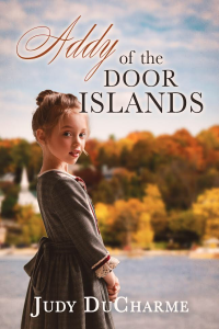Addy of the Door Islands. Addy stands next to the water (with land in the background) gazing back at the reader