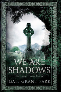 celtic cross in center of a woman's shadowy face outlines by a tree